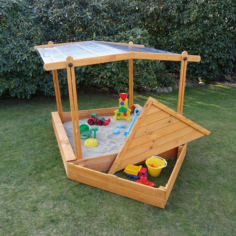 Sandkasten aus Holz mit Dach und Spielzeug