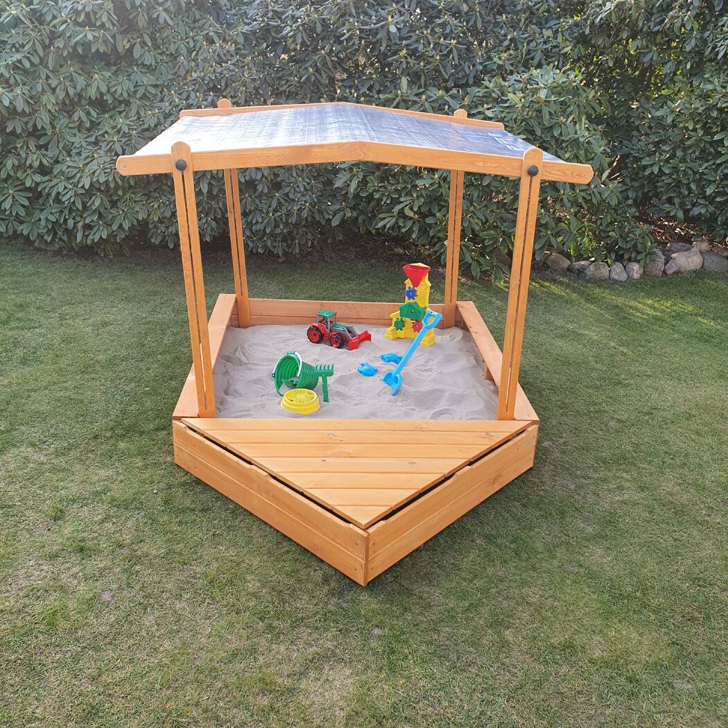 Hölzerner Sandkasten mit Dach und Sandspielzeug