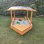 Hölzerner Sandkasten mit Dach und Sandspielzeug