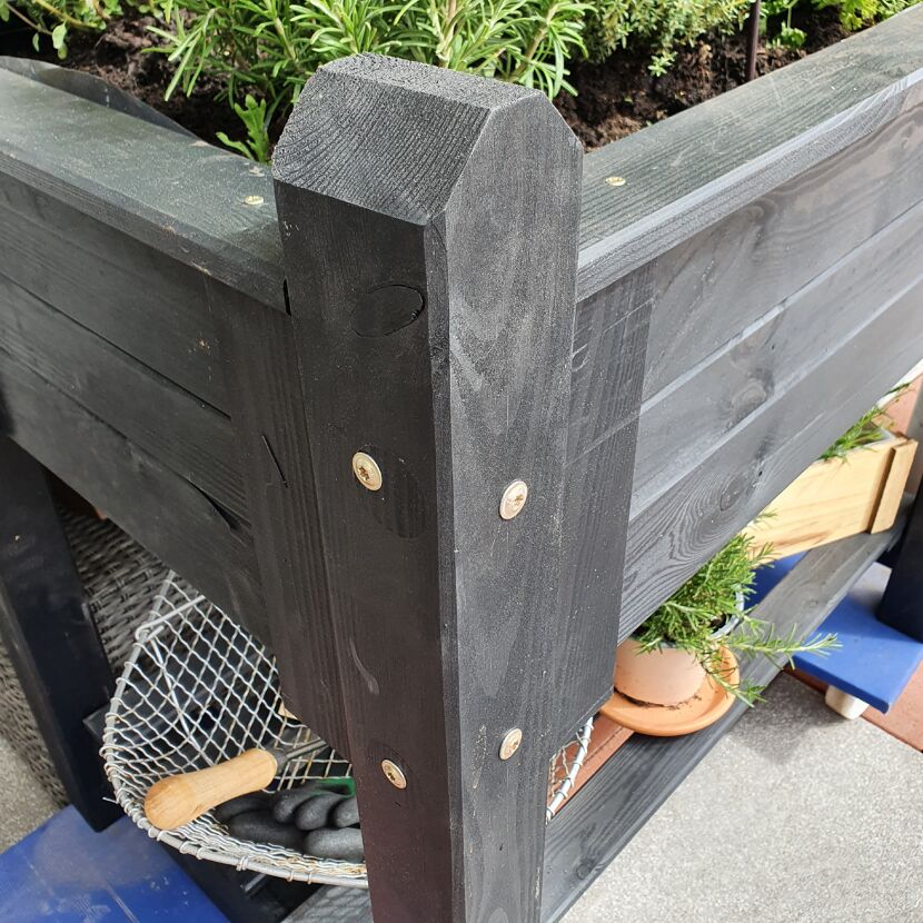 Ecke eines schwarzen Hochbeets mit Schrauben