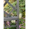 Schwarzes Holzgitter vor Blumen