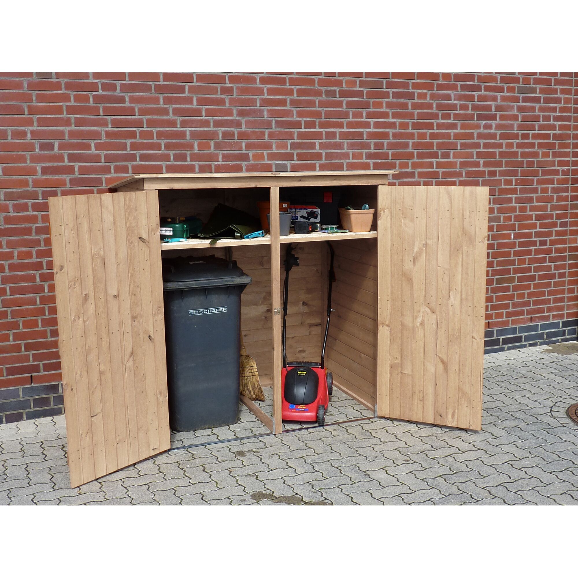 Geöffneter Mülltonnenschrank mit Rasenmäher