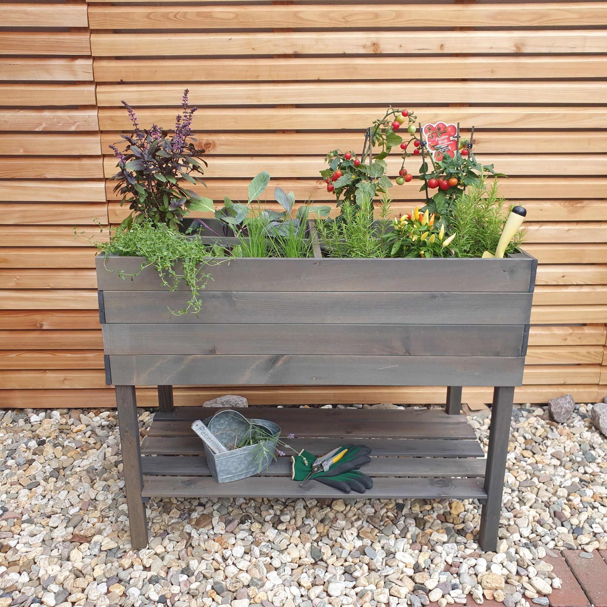 Erhöhtes Kräuterbeet mit Gartenwerkzeug