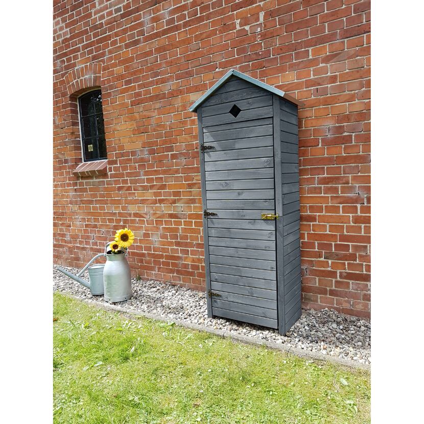 Grauer Gartenschrank an Backsteinwand
