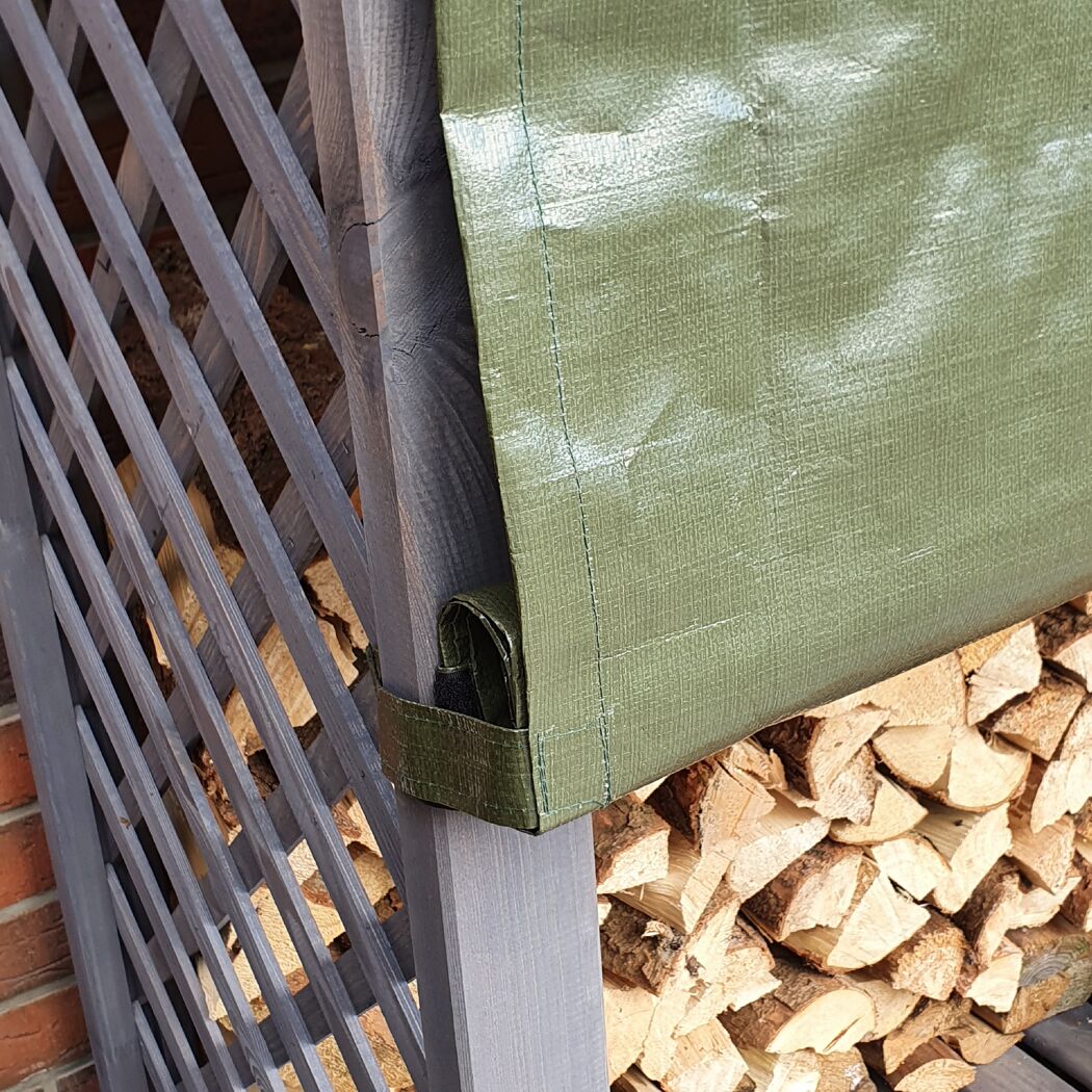 Grauer Holzstapel mit grüner Plane