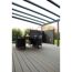 Tisch und Stühle auf Terrassendielen unter einem Terrassendach