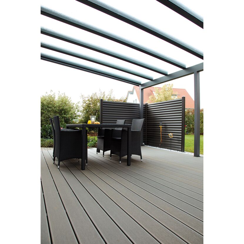 Tisch und Stühle auf Terrassendielen unter einem Terrassendach