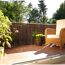 Balkon mit Farnmatte, Korbmöbeln und Blumen