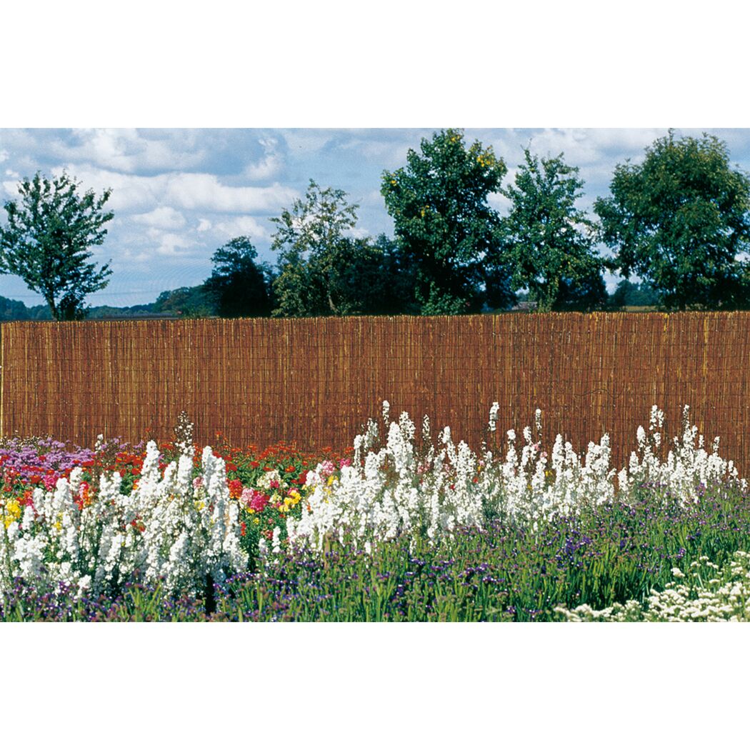 Gartenzaun aus Farnmatten hinter Blumenbeeten