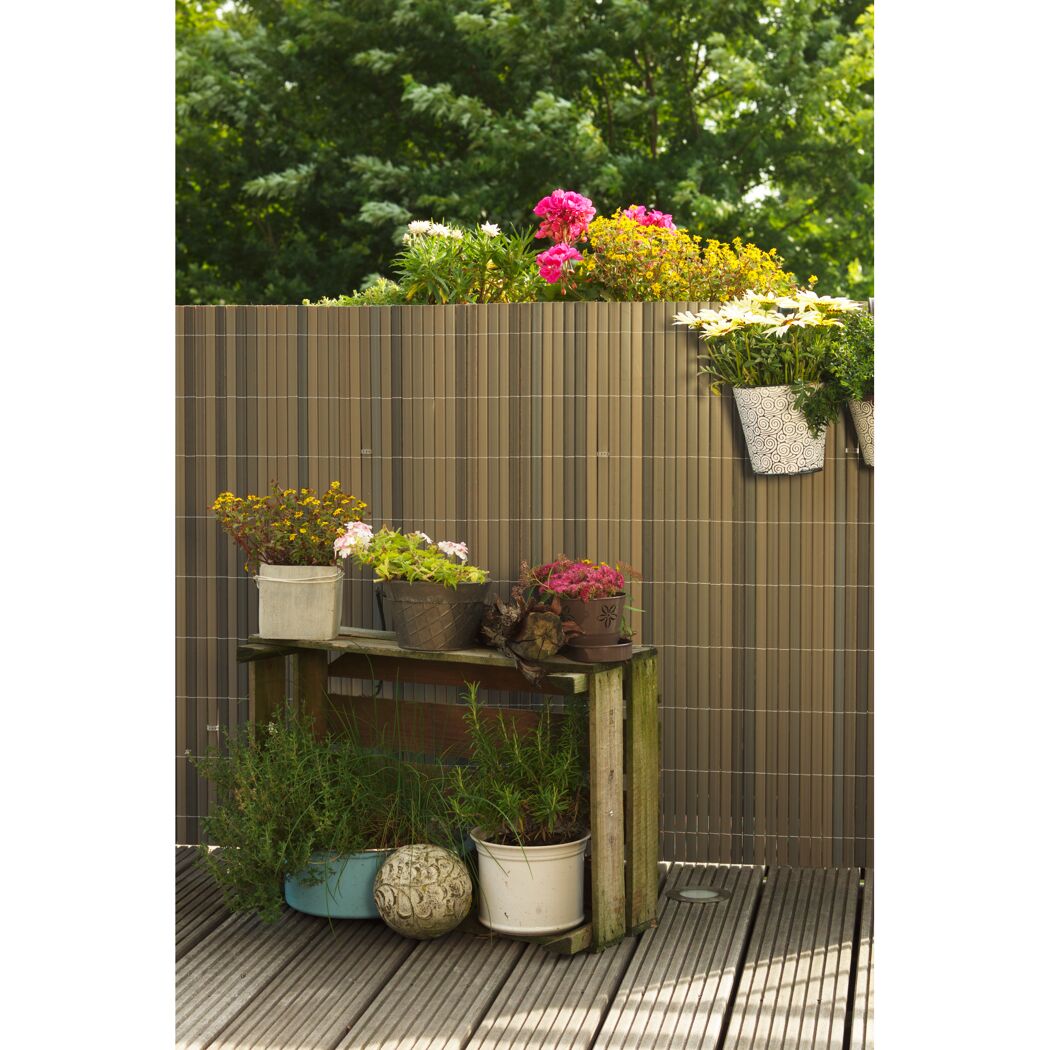 Blumenkästen und -töpfe auf einem Balkon mit Sichtschutz