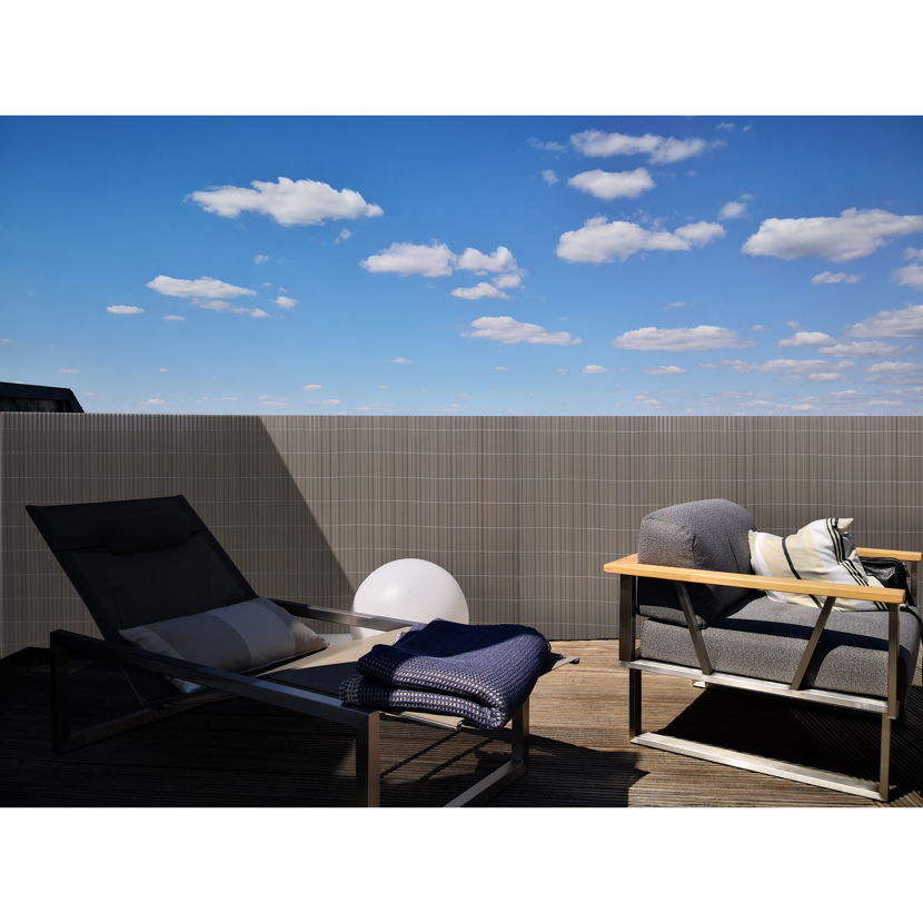 Gartenmöbel hinter einem Sichtschutz auf einer Terrasse
