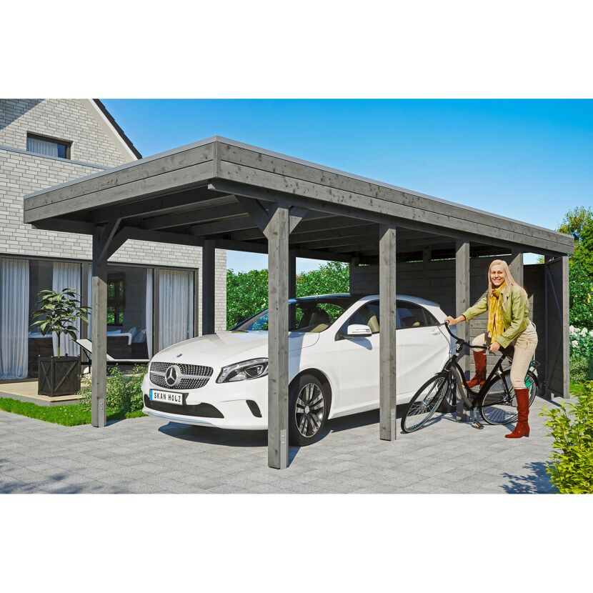 Person schiebt Fahrrad unter Carport.