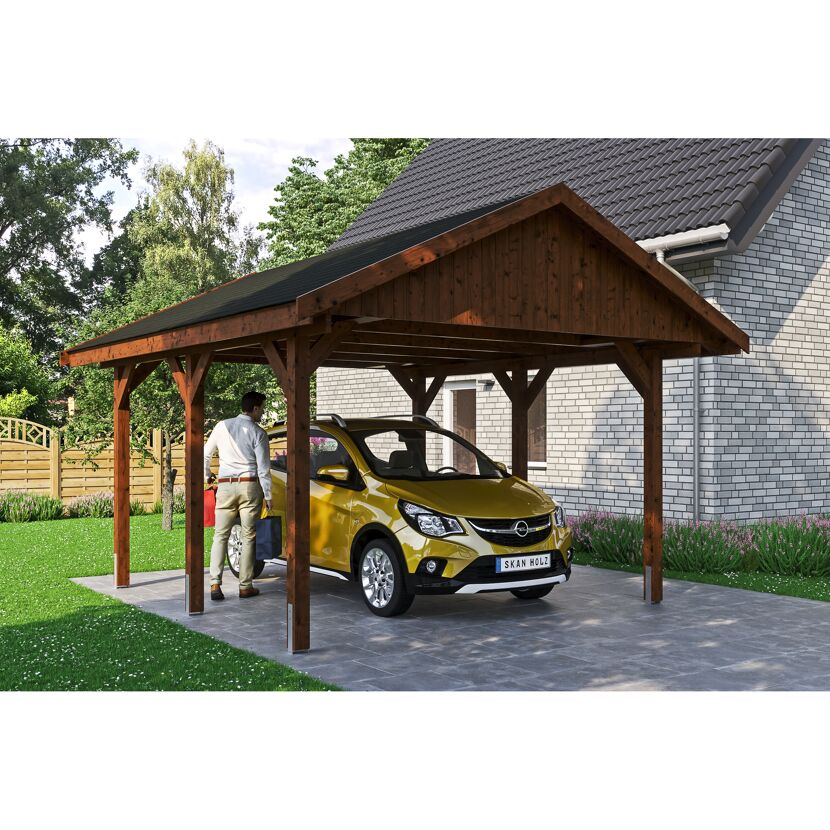Person parkt gelbes Auto unter einem braunen Carport