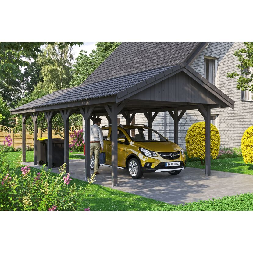 Person parkt gelbes Auto unter einem grauen Carport.