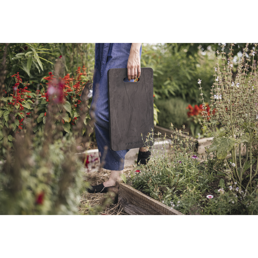Person verwendet Knieschoner im Garten.