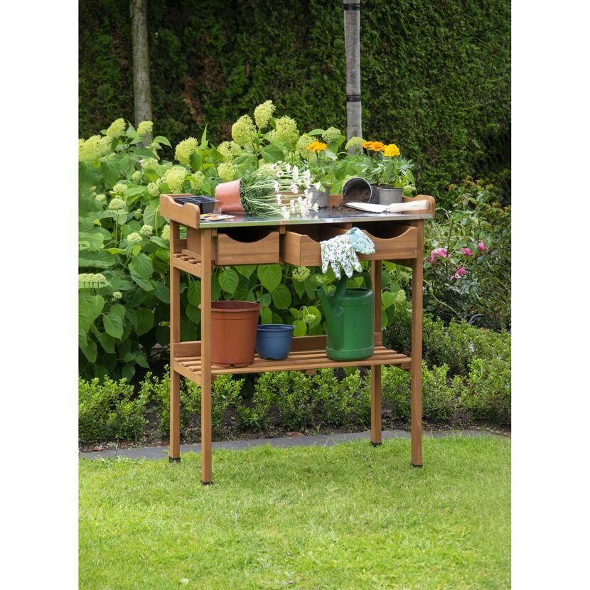 Holztisch mit Gartenwerkzeug und Blumen