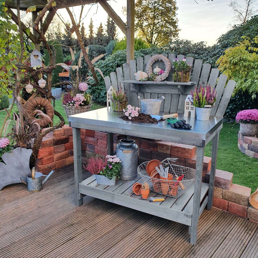 Gärtnertisch mit Gartengeräten und Blumen