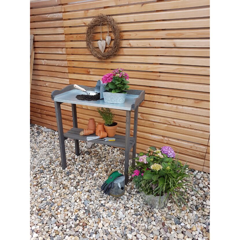 Gartentisch mit Gartenzubehör und Pflanzen