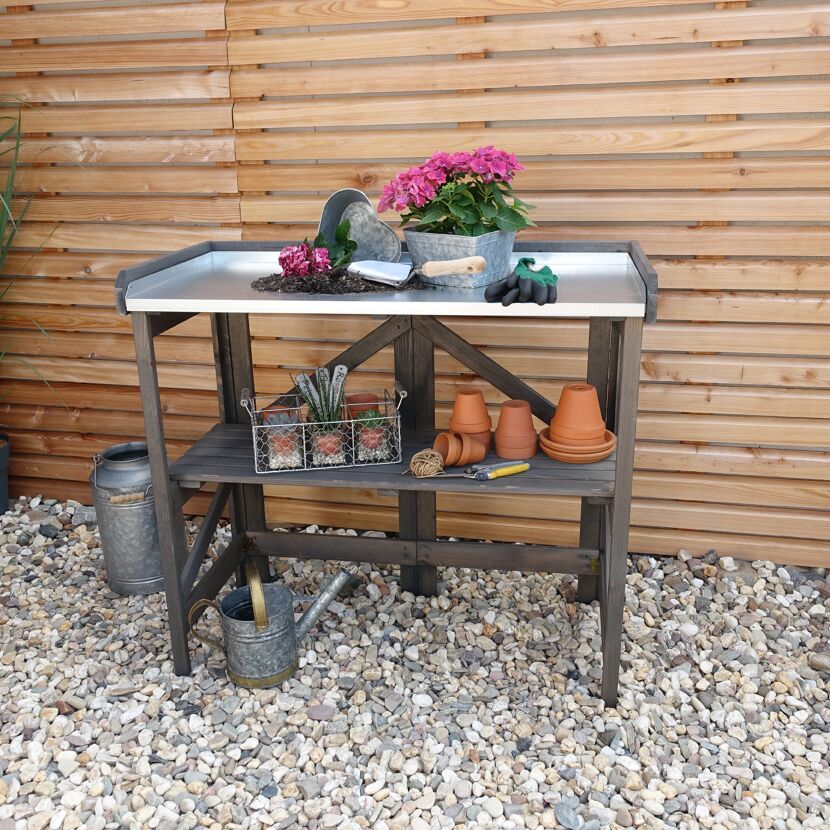 Gartentisch mit Blumentöpfen und Gartengeräten
