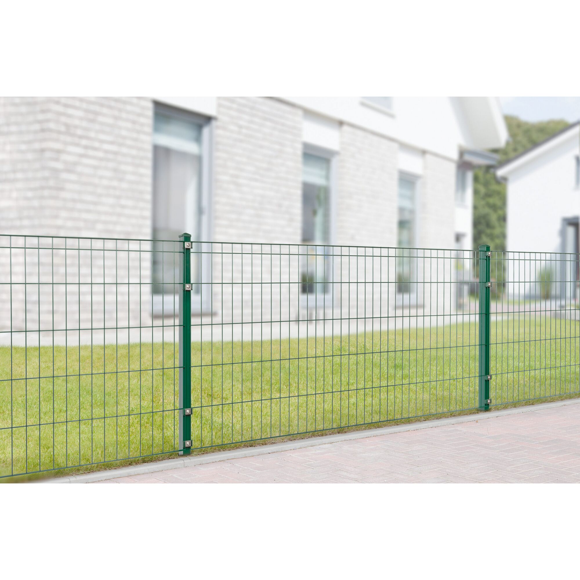 Grüner Metallzaun vor einem Haus