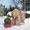 Drei in Jute eingepackte Topfpflanzen im Schnee