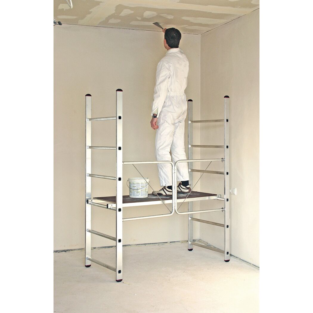 Person auf einem Klappgerüst beim Spachteln der Decke