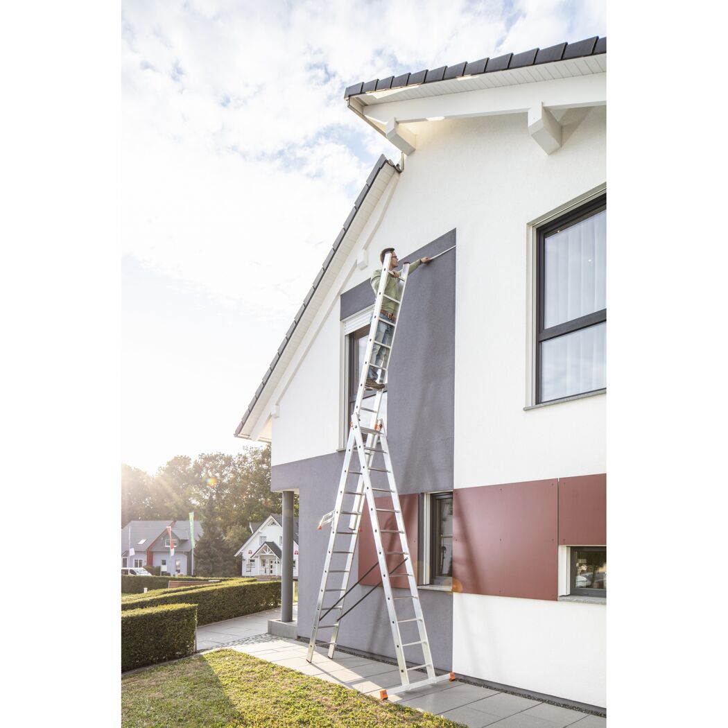 Person auf Leiter an Hausfassade