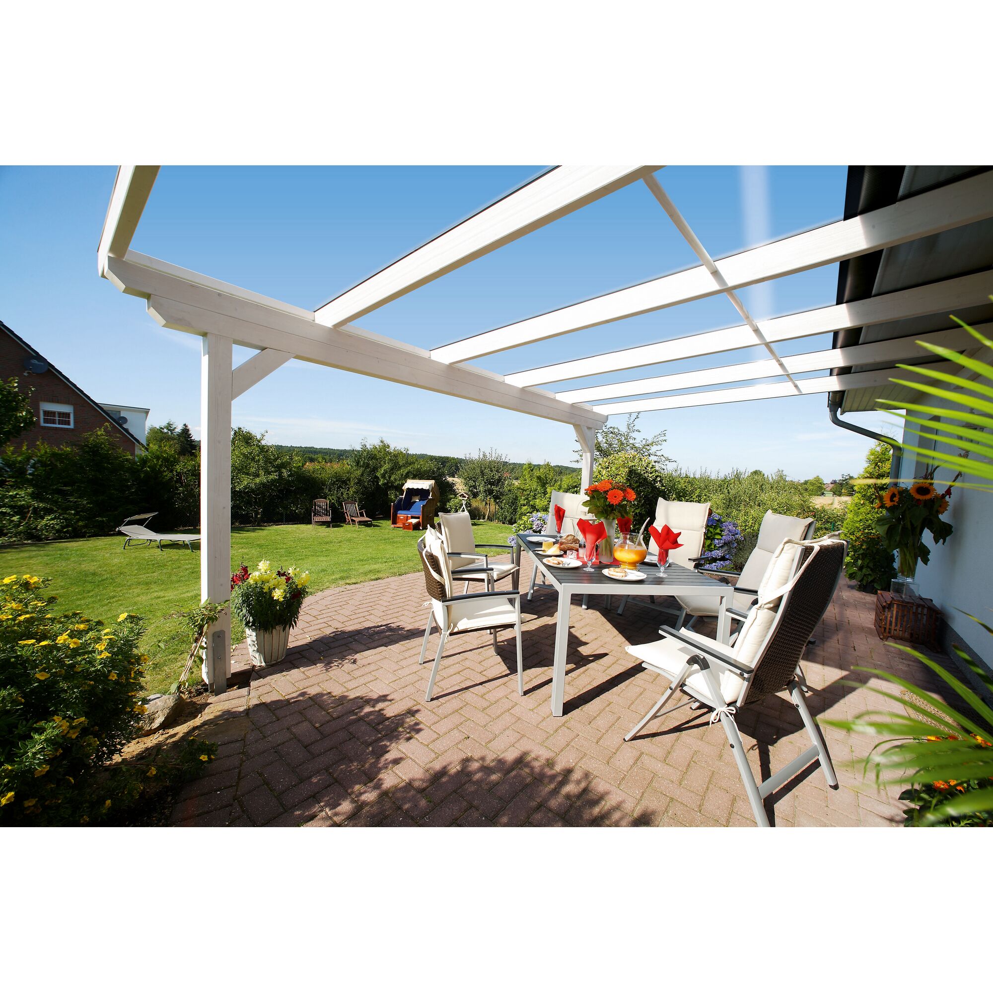 Überdeckte Terrasse mit Tisch und Stühlen im Garten