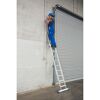 Person auf Anlegeleiter mit Werkzeug an Wand