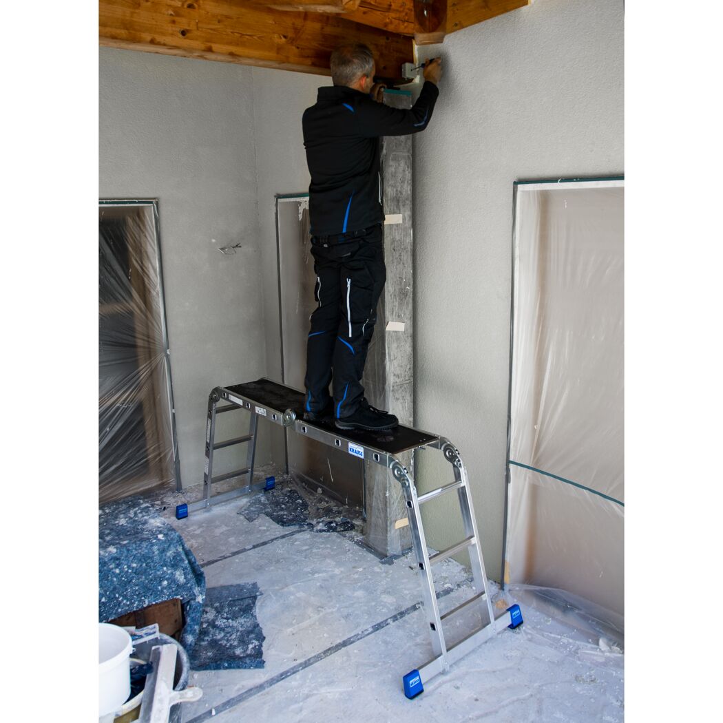 Person auf KRAUSE Gelenkleiter mit Plattform