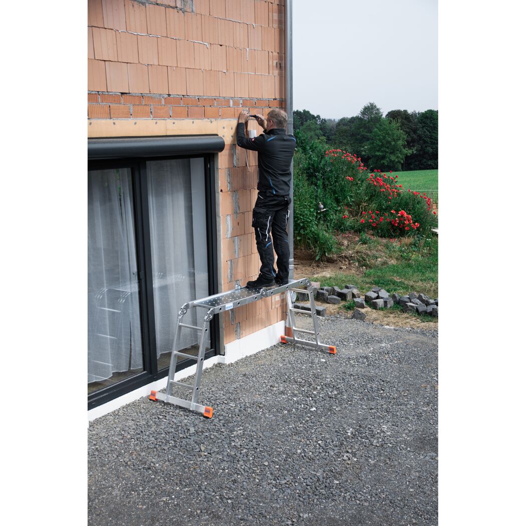 Person auf einer Leiter an einer Hauswand