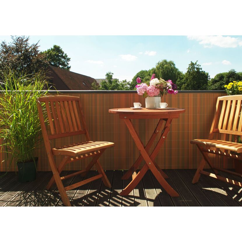 Balkon mit Holztisch, Stühlen, Blumen und Balkonverkleidung