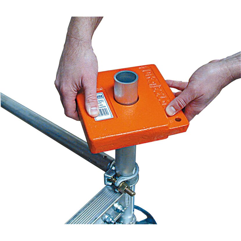 Person befestigt orangefarbenes Ballastgewicht Climtec am Gerüst.