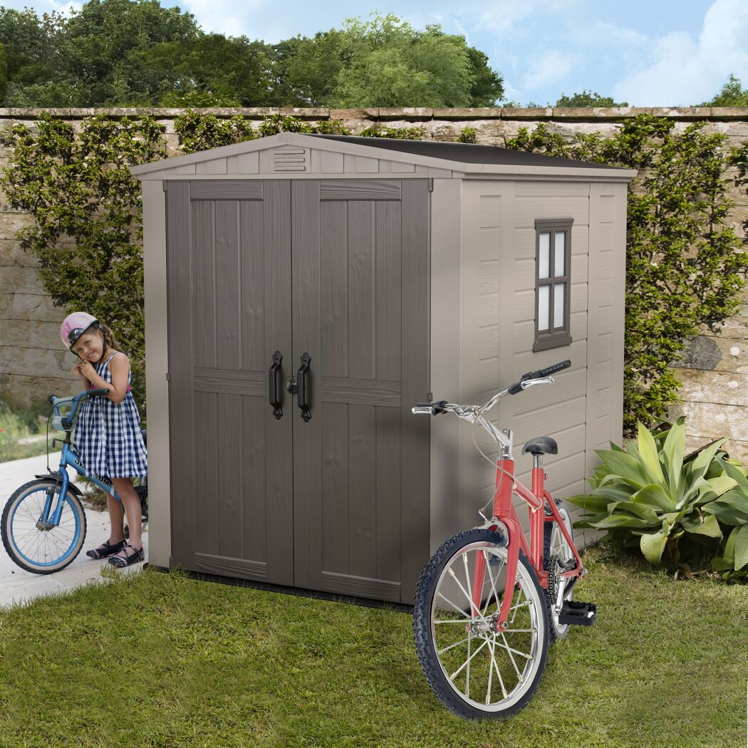 Kind mit Fahrrad neben Kunststoffgerätehaus Factor 6x6