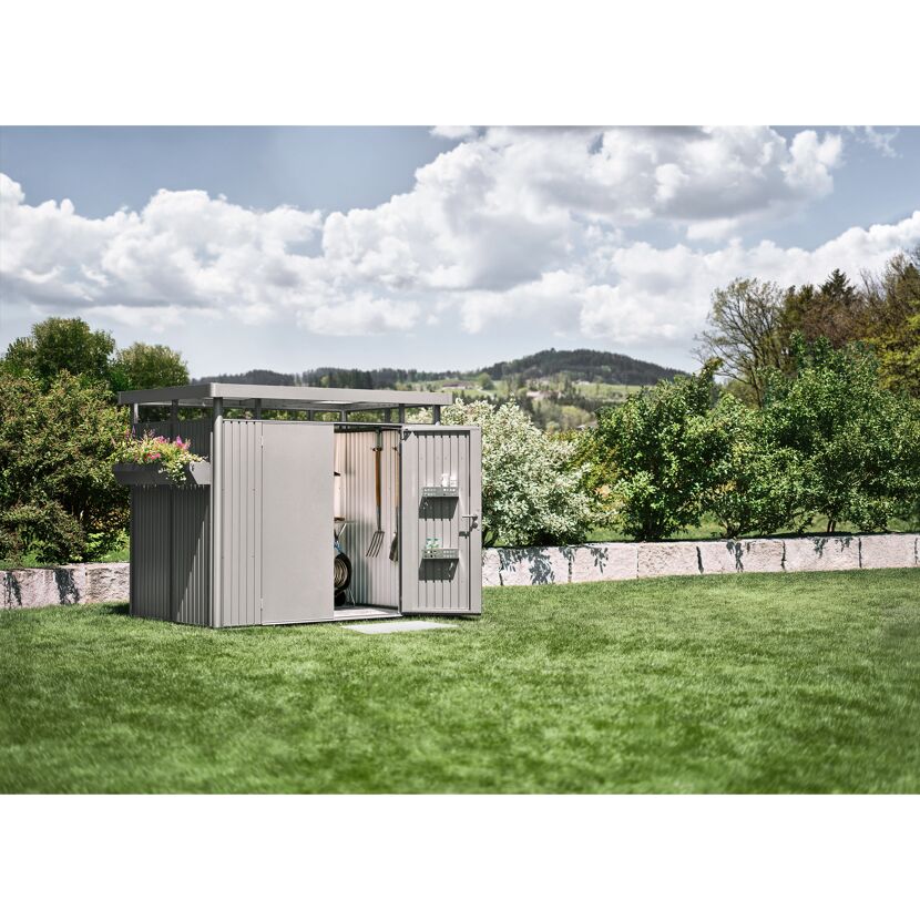 Silbernes Gerätehaus 'Highline H2' im Garten mit offenen Türen und Gartengeräten.