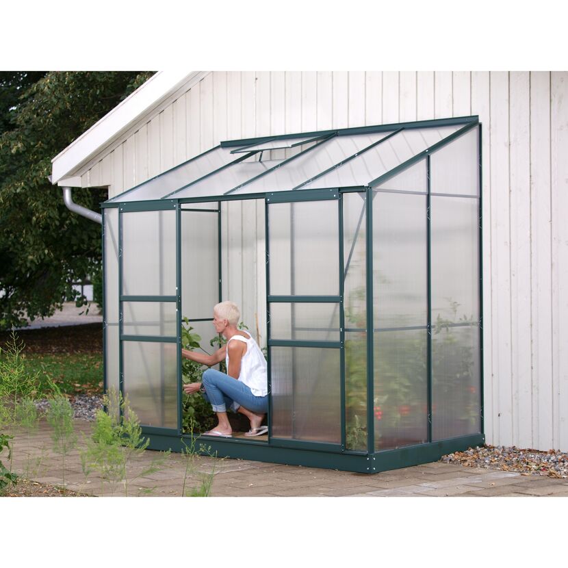 Person in einem Gewächshaus aus transparentem Kunststoff
