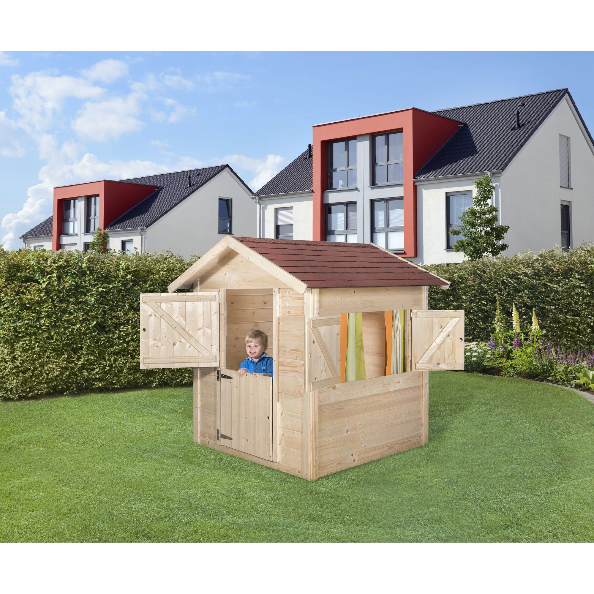 Kind in einem Spielhaus aus Holz im Garten