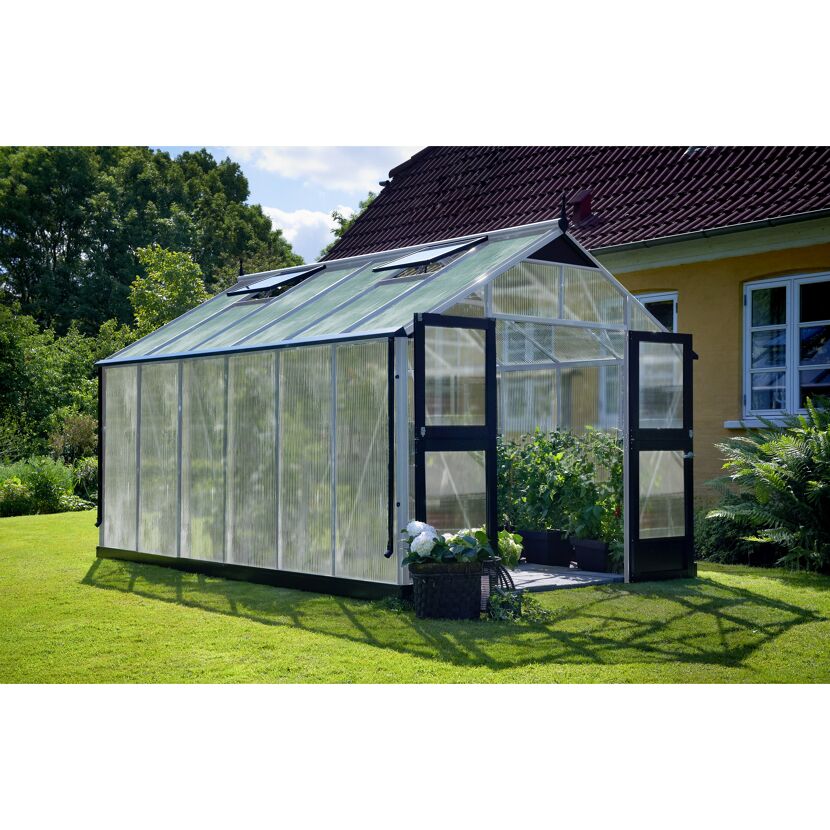 Gewächshaus GWH Premium mit geöffneter Tür und Pflanzen im Inneren.