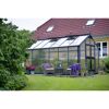 Gewächshaus im Garten mit Sitzmöbeln davor