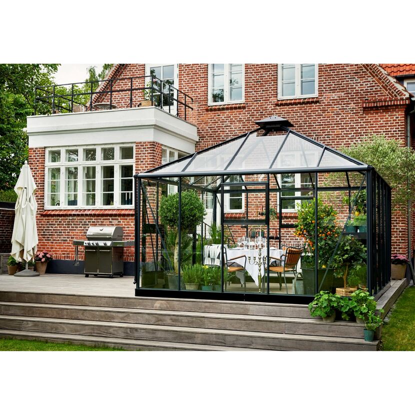 Gewächshaus mit Esstisch auf einer Terrasse