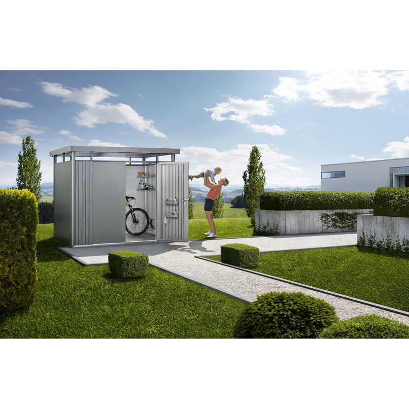 Metallgerätehaus im Garten, Person hebt Kind hoch