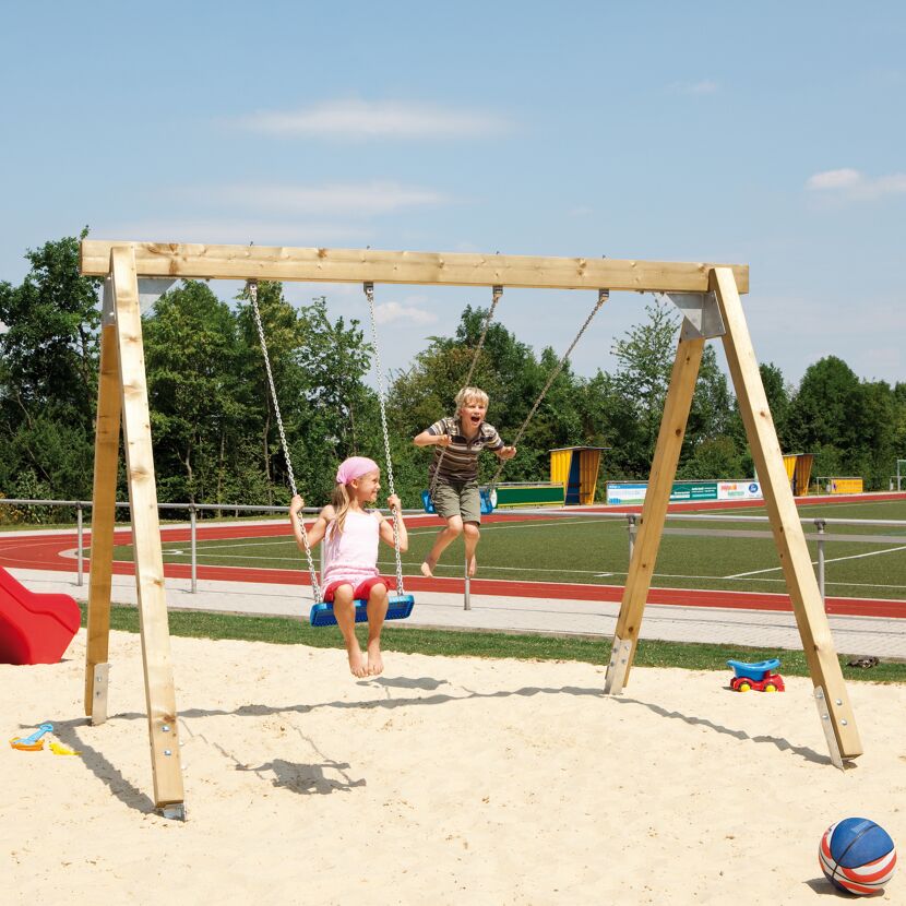 Zwei Kinder schaukeln auf einer Holzschaukel.