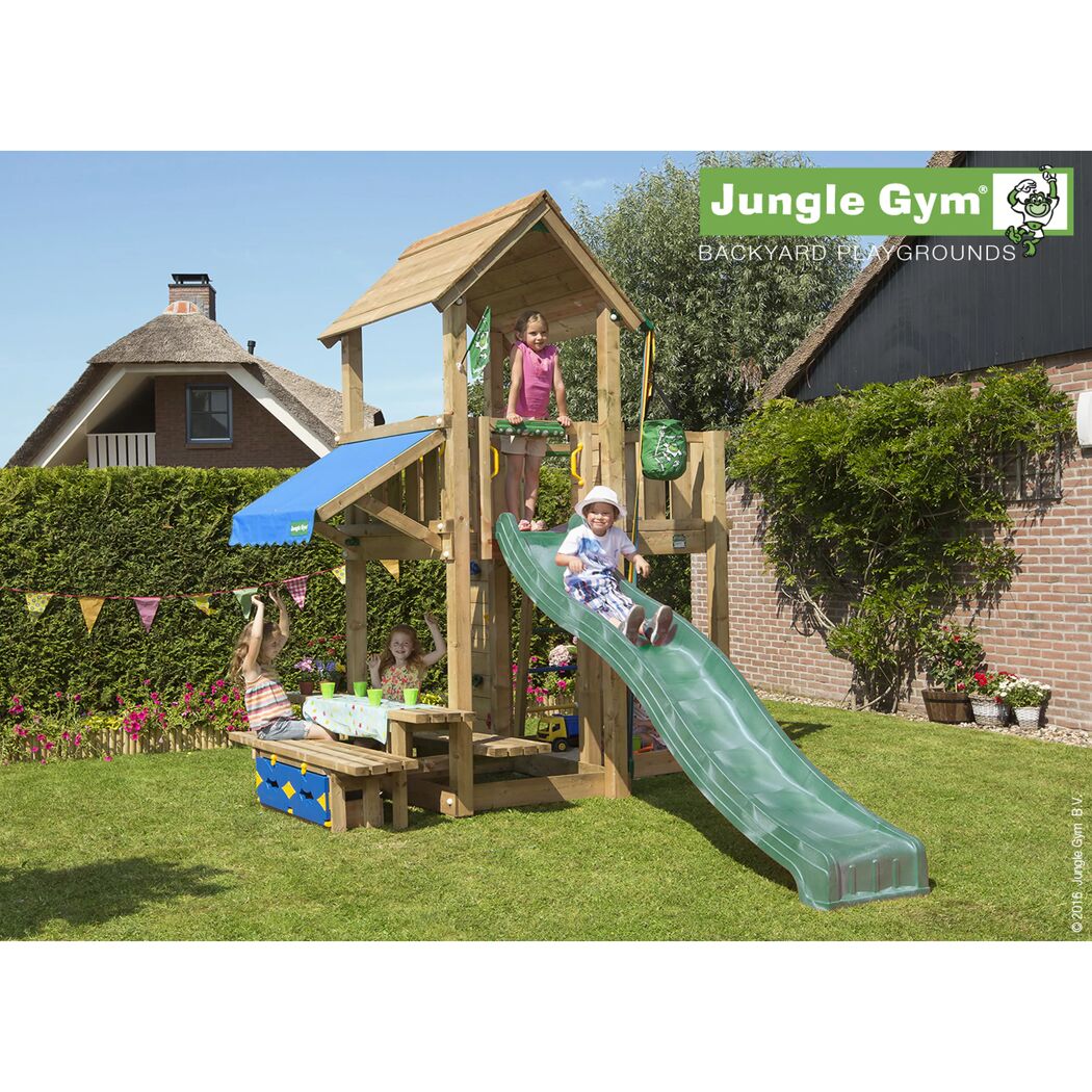Kinder spielen auf einem Jungle Gym Spielturm mit Rutsche und Picknicktisch.