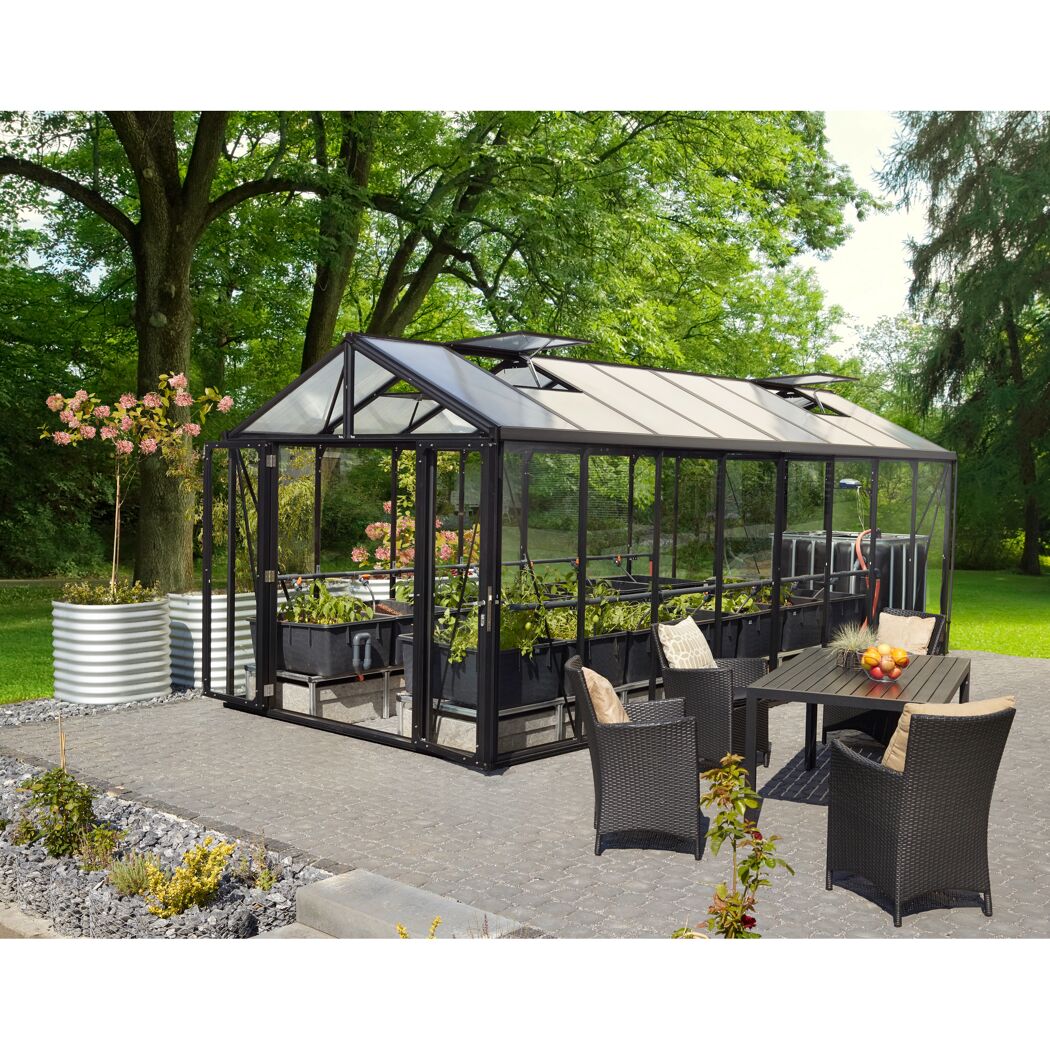 Gewächshaus Zeus Comfort mit Sitzgruppe im Garten
