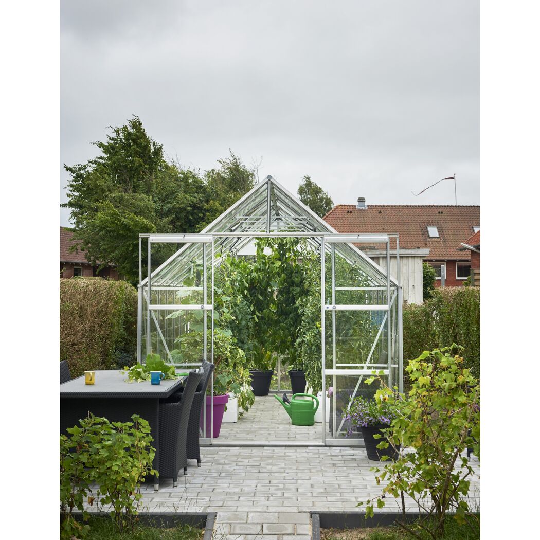 Gewächshaus mit Gießkanne im Garten