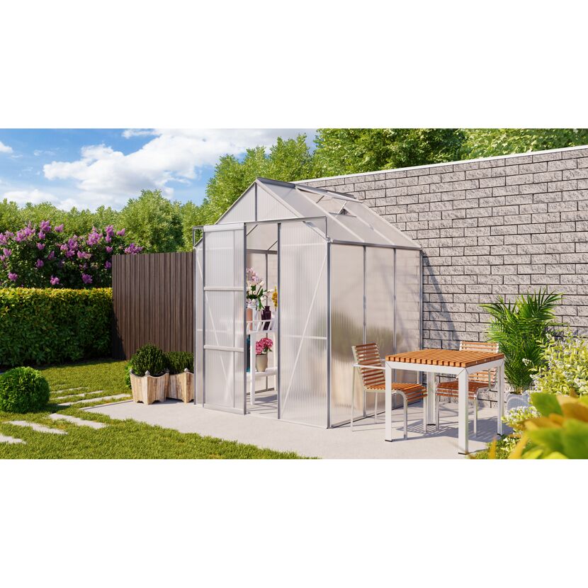 Gewächshaus im Garten mit Tisch und Stühlen davor