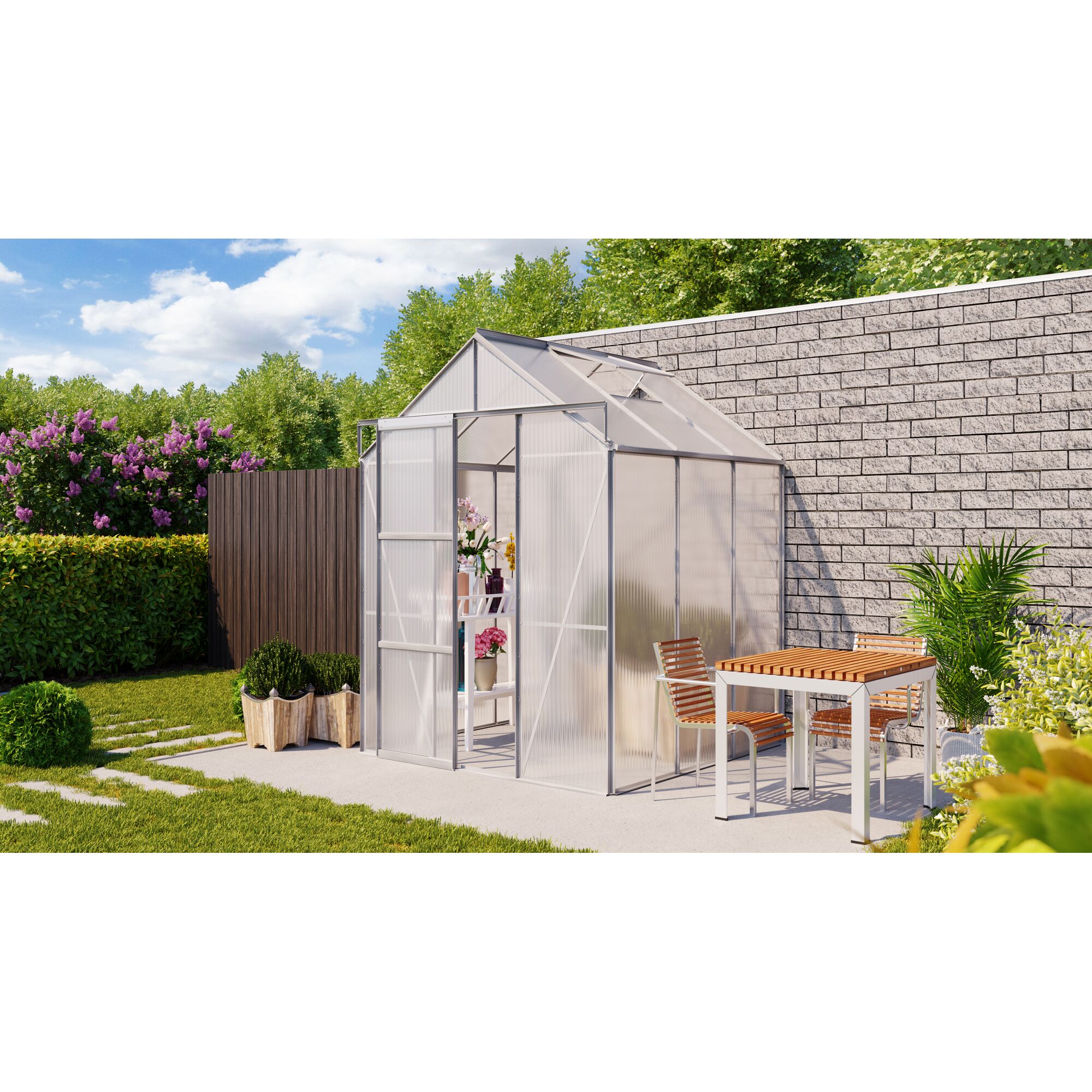 Gewächshaus im Garten mit Tisch und Stühlen davor