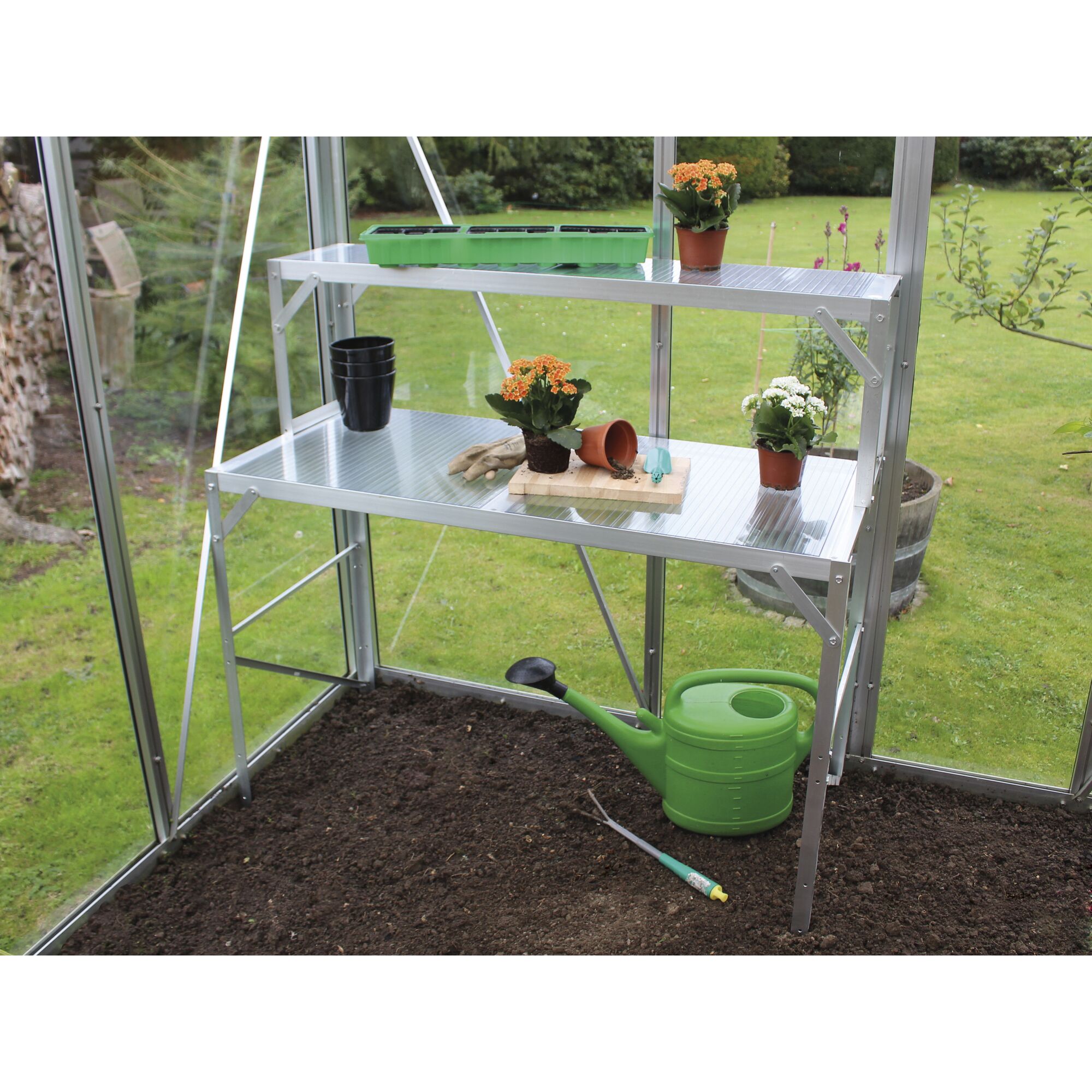 Gewächshausregal mit Blumentöpfen und Gießkanne