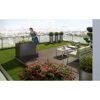 Person pflegt Kräuter im Hochbeet auf Dachterrasse