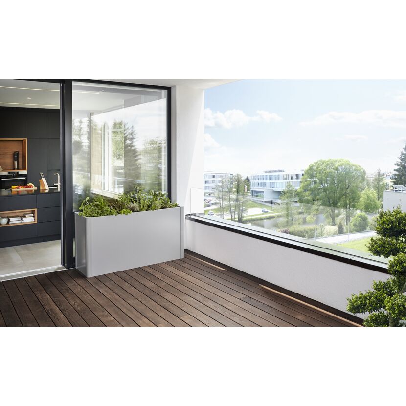 Grauer Blumenkasten auf Balkon mit Holzboden